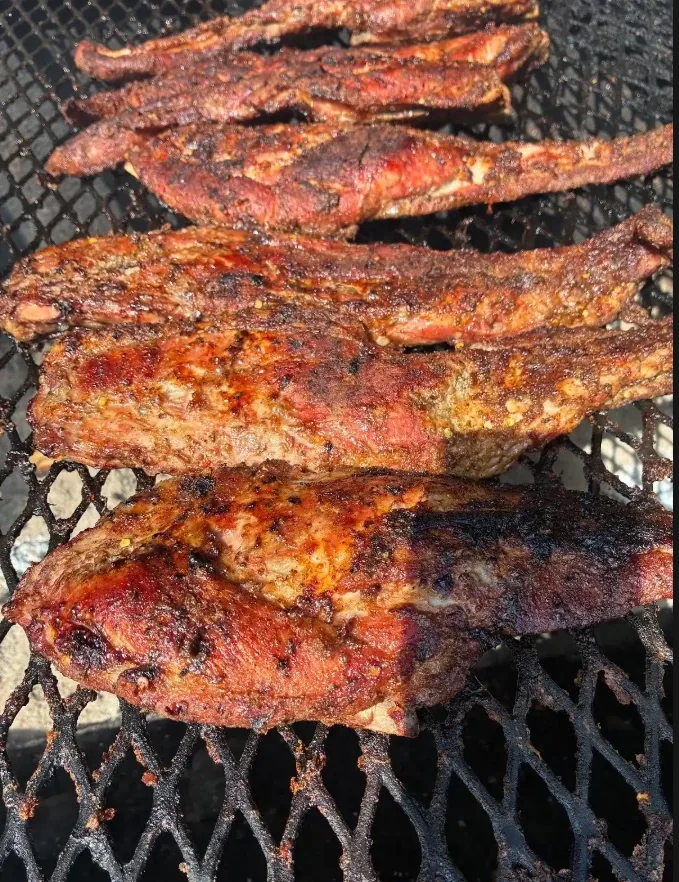 Jerk rib tips smoking over the charcoal grill